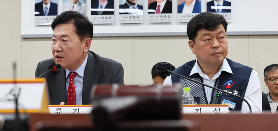 Ryu Ki-jung, left, a representative from the Korea Employers Federation, and Ryu Ki-seob, a representative from the Federation of Korean Trade Unions, attend the first plenary session of the Minimum Wage Commission held at the government complex in Sejong on Tuesday. [YONHAP]