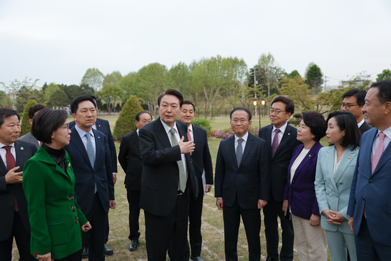 President Yoon Suk Yeol, center, in meeting with People Power Party lawmakers at the lawn of the newly opening Yongsan Children's Garden on Tuesday. [PRESIDENTIAL OFFICE]