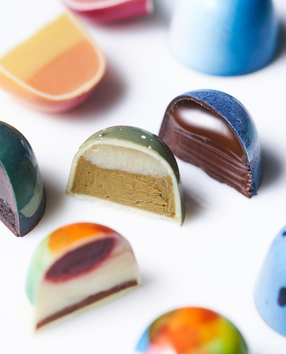A pleasantly snappy bite reveals dainty confections infused with ingredients like lime, matcha or sesame seed as well as more classic sea salt caramel or gianduja hazelnut fillings. [SCREEN CAPTURE/STICK WITH ME SWEETS KOREA]