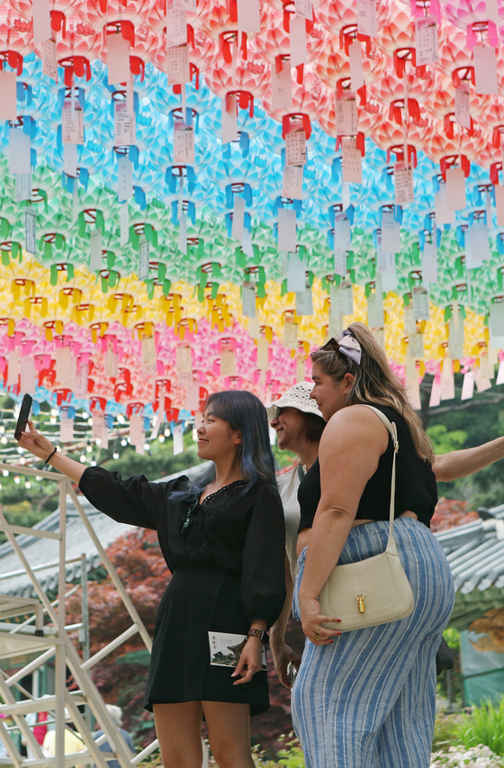 Visitors take a selfie with their mobile phone at Jeondeungsa Temple in Ganghwa County, Incheon, on Thursday. Sixty-five nationwide temples that hold or manage designated cultural properties and charge admission fees waived their fees for the day, including Jeondeungsa Temple. [YONHAP]