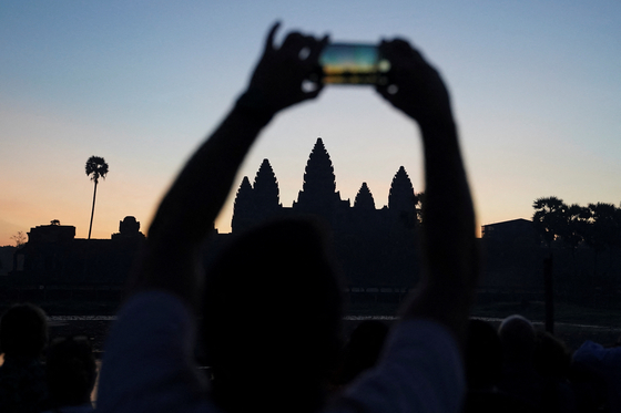 A tourist takes a picture of the sunrise at the Angkor Wat temple in Siem Reap, Cambodia, on Jan.14. [REUTERS/YONHAP]