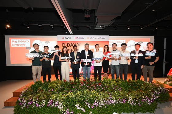 Edwin Low, center, director of Singapore's Infocomm Media Development Authority, poses with start-ups that participated in the D.Camp's D.Day, on Thursday. [D.CAMP]