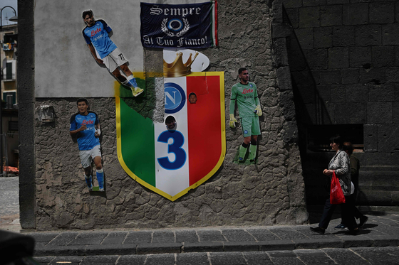 A woman walks past a large picture of Kim Min-jae set up by Napoli fans on a wall in Naples, Italy on Thursday. The banner reads ″Always at your side.″ [AFP/YONHAP]