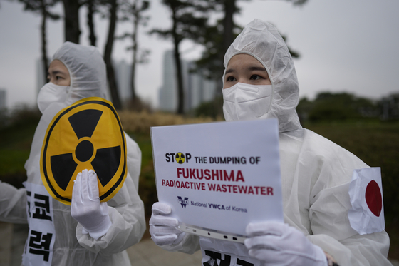 People hold banners during a rally demanding the withdrawal of Japanese government's decision to release treated radioactive water from the Fukushima, in Seoul on April 6. [AP/YONHAP]