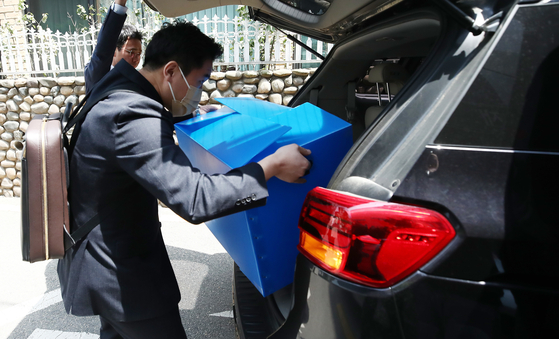 Financial authorities on April 27 load confiscated items after raiding an office in Gangnam, southern Seoul, used by alleged stock manipulators. [NEWS1]