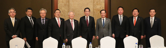 Business leaders and foreign envoys pose for a photo after a meeting with Japanese Prime Minister Fumio Kishida, sixth from left, at the Lotte Hotel in central Seoul on Monday. From left: Japanese Ambassador to Korea Koichi Aiboshi; Japan’s Deputy Chief Cabinet Secretary Seiji Kihara; the Federation of Middle Market Enterprises of Korea Chairman Choi Jin-shik; the Korea International Trade Association Chairman Koo Ja-yeol; the Korea Enterprises Federation Chairman Sohn Kyung-shik; Japanese Prime Minister Fumio Kishida; the Federation of Korean Industries Chairman Kim Byong-joon; the Korea Chamber of Commerce and Industry Chairman Chey Tae-won; the Korea Federation of SMEs Chairman Kim Ki-moon; the Korea-Japan Economic Association Chairman Kim Yoon [THE FEDERATION OF KOREAN INDUSTRIES]