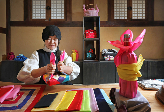 Lee Hyo-jae, hanbok (traditional Korean dress) designer and bojagi (traditional wrapping cloth) artist, is demonstrating how to wrap bojagi during a class at Chojeong Haenggung in Cheongju, North Chungcheong. [PARK SANG-MOON]
