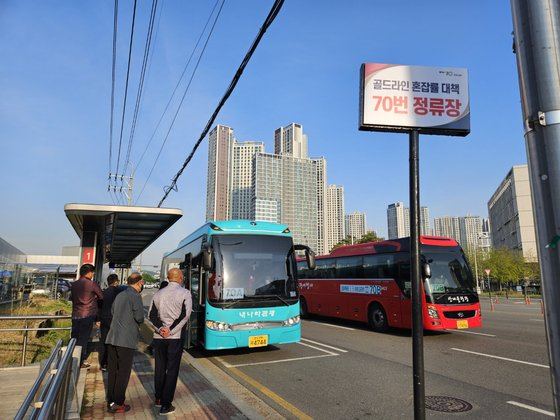 People stand at a bus stop near Geolpo Bukbyeon Station in Gimpo to get on a bus on Monday morning. [JANG SEO-YUN]