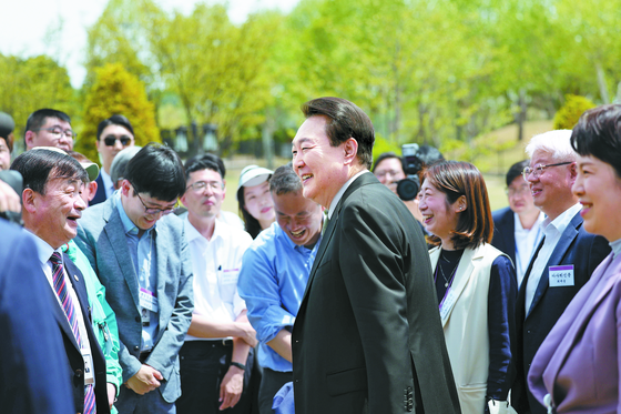 President Yoon Suk Yeol, center, speaks to reporters at an event marking the opening of the Yongsan Children's Garden in front of the presidential office in central Seoul on May 2 ahead of the one-year anniversary of his inauguration. [PRESIDENTIAL OFFICE]