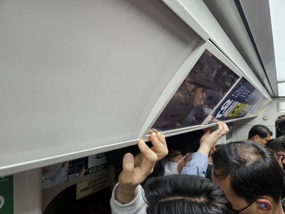 Passengers hold onto the wall, barely able to stand, on a Gimpo Gold Line subway train on Monday morning. [YUN JEONG-MIN]