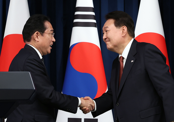 Japanese Prime Minister Fumio Kishida, left, shakes hands with Korean President Yoon Suk Yeol after their joint press conference following their summit at the presidential office in Yongsan District, central Seoul, on Sunday afternoon. [YONHAP]