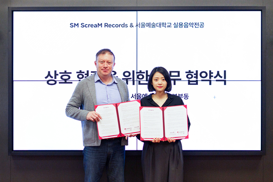 President of the Seoul Institute of the Arts Yoo Tay-guhn, left, poses with the leader of ScreaM Records Chae Jung-hee, after signing a memorandum of understanding (MOU) on Tuesday at the arts school's Ansan campus in Gyeonggi. [SM ENTERTAINMENT]