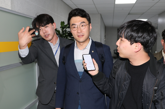 Democratic Party lawmaker Kim Nam-kuk, center, is questioned by reporters about his cryptocurrency investments as he leaves the National Assembly in Yeouido, western Seoul on Tuesday afternoon. [YONHAP]