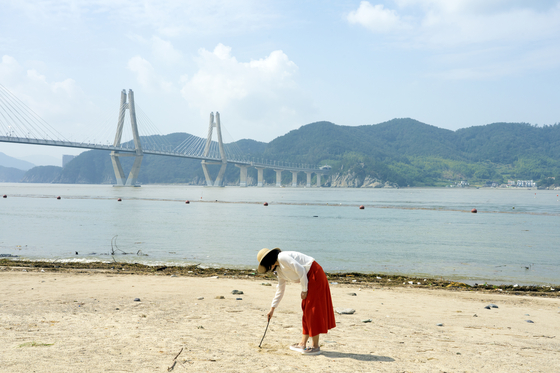 A visitor leaves a mark on the beach of Jeo Island in Geoje, South Gyeongsang. [BAEK JONG-HYUN]