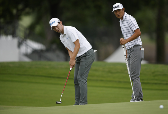 Noh Seung-yul putts to save par on the 16th hole as James Hahn of the United States looks on during the first round of the AT&T Byron Nelson at TPC Craig Ranch on Thursday in McKinney, Texas.  [GETTY IMAGES]
