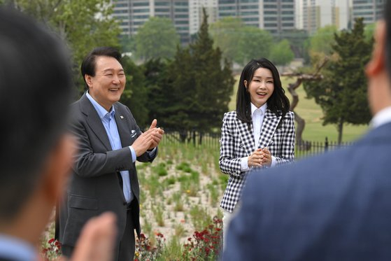 President Yoon Suk Yeol, left, and first lady Kim Keon-hee applaud after a luncheon marking the opening of the Yongsan Children's Garden in central Seoul on May 4. [PRESIDENTIAL OFFICE] 