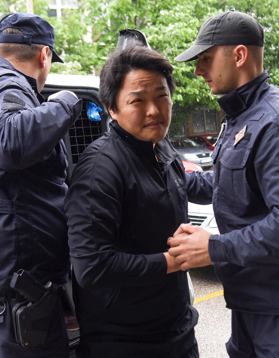 Police officers escort disgraced crypto company founder Do Kwon, center, in Podgorica, Montenegro, Thursday. [EPA/YONHAP]