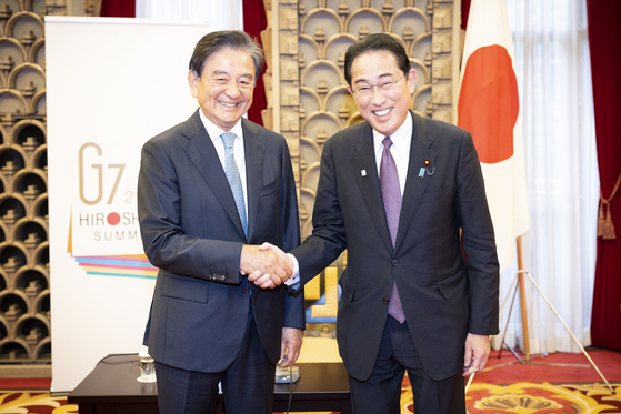 Japanese Prime Minister Fumio Kishida, right, shakes hands with JoongAng Holdings Chairman Hong Seok-hyun at the prime minister’s office in Tokyo on Thursday. [JUN MIN-KYU]