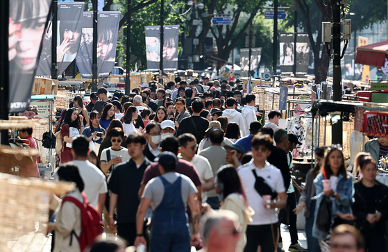 The streets of Myeong-dong bustles with pedestrians on Sunday. [YONHAP]