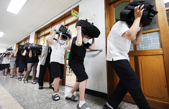 Students at Chilbo Middle School in Suwon, Gyeonggi, participate in an earthquake evacuation drill on Monday. [YONHAP]