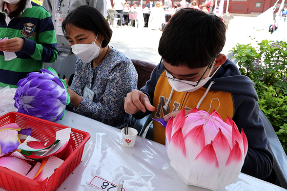 People make their own lanterns at booths near Jogye Temple in Jongno District, central Seoul, last year [JOONGANG ILBO]