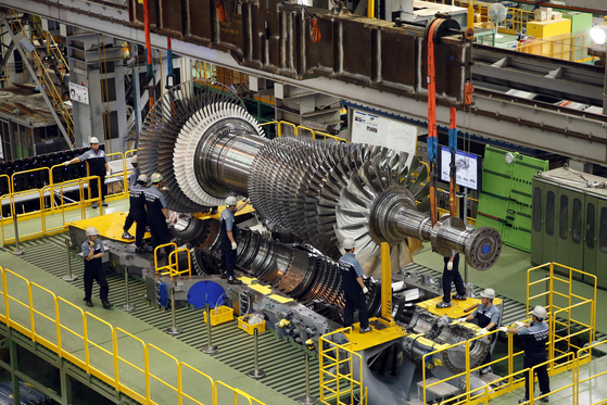 Doosan Enerbility employees work on the final assembly of a large-scale gas turbine. [DOOSAN ENERBILITY]