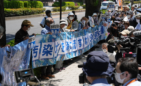 People rally in front of the Second Members' Office Building of the House of Representatives to protest the Japanese government's plan to discharge treated radioactive water into the sea in Tokyo, on Tuesday. Hundreds of Japanese people gathered at multiple locations in Tokyo on Tuesday to protest the government's plan to discharge contaminated water from the crippled Fukushima Daiichi Nuclear Power Plant into the sea, demanding the immediate suspension of the plan. [XINHUA/YONHAP]