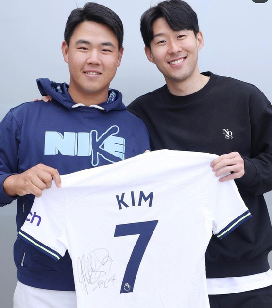 PGA Tour golfer Tom Kim, also known as Kim Joo-hyung, poses with Tottenham Hotspur midfielder Son Heung-min after receiving a tour of Tottenham Hotspur Stadium in London. Kim visited London at the end of April and met Son and teammate Harry Kane. The image was uploaded on the PGA Tour's official Twitter page on Wednesday with the caption ″A dream come true for @SpursOfficial fan @JoohyungKim0621. He toured the stadium in London and met legends @HKane and @Sonny7.″  [SCREEN CAPTURE]