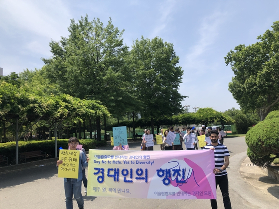 Students and faculty march across Kyungpook National University's campus while holding signs that condemn discrimination against Muslims. [YONHAP]