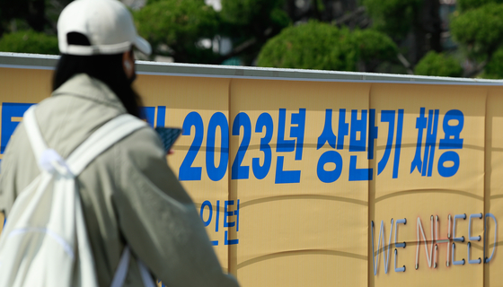 A person walks past a recruitment banner at a university campus in downtown Seoul on March 20. [NEWS1]
