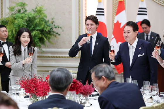 President Yoon Suk Yeol, right, and first lady Kim Keon-hee, left, gives a toast to Canadian Prime Minister Justin Trudeau, center, at a dinner banquet at the Blue House in central Seoul Wednesday. [JOINT PRESS CORPS] 