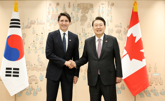 Korean President Yoon Suk Yeol, right, shakes hands with Canadian Prime Minister Justin Trudeau ahead of their summit at the Yongsan presidential office in central Seoul Wednesday. [JOINT PRESS CORPS]