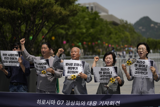 Members of civic groups shout slogans during a rally calling for Korea and Group of 7 nations to express their objection to the Japanese government's decision to release treated radioactive water from the Fukushima nuclear power plant and condemning the People Power Party's response to it, in Seoul on Wednesday. [AP/YONHAP]