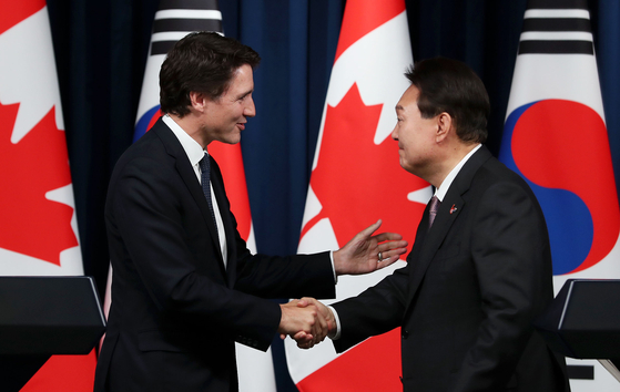 Korean President Yoon Suk Yeol, right, shakes hands with Canadian Prime Minister Justin Trudeau at a joint press conference after their bilateral summit at the Yongsan presidential office in central Seoul Wednesday. [JOINT PRESS CORPS]