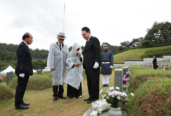 President Yoon Suk Yeol, center, pays respects to families of victims of the 1980 pro-democracy uprising at the national cemetery in Gwangju on Thursday ahead of a ceremony marking the 43rd anniversary of the May 18 Democratization Movement. [JOINT PRESS CORPS]