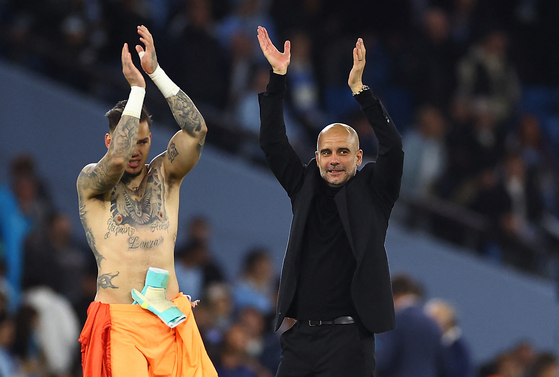 Manchester City manager Pep Guardiola, right, celebrates with Ederson after beating Real Madrid in the second leg of the Champions League semifinals at Etihad Stadium in Manchester, England on Wednesday. [REUTERS/YONHAP]