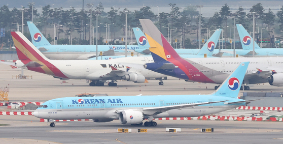 Korean Air Lines and Asiana Airlines planes parked at Incheon International Airport on Thursday. [YONHAP]