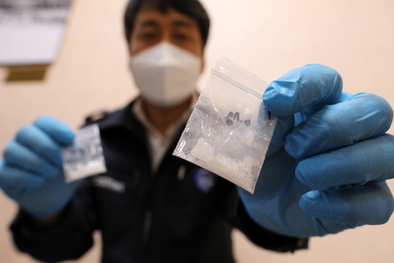 An official holds up bags containing drugs during an inter-department meeting on drugs held at the Seoul Regional Customs office in Gangnam District, southern Seoul, on Thursday. The Korea Customs Service announced on the same day that the quantity of drugs confiscated by the governmental organization reached an all-time high this year. [NEWS1] 