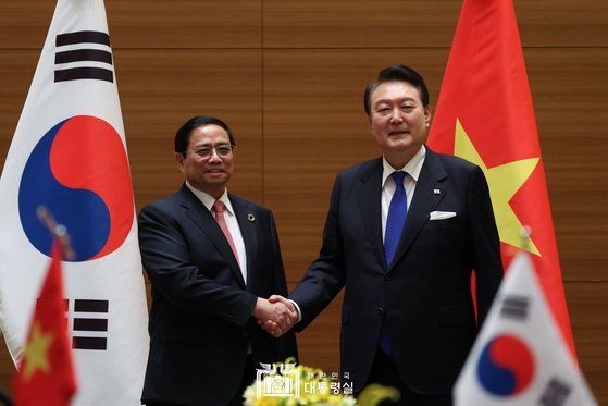 President Yoon Suk Yeol, right, shakes hands with Vietnamese Prime Minister Pham Minh Chinh at their summit in Hiroshima on Friday. [PRESIDENTIAL OFFICE] 