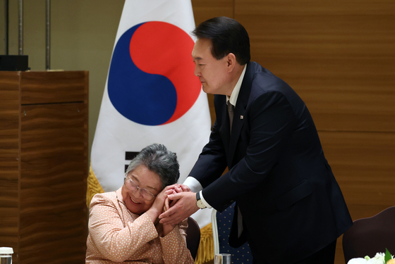 President Yoon Suk Yeol, right, meets with a Korean victim of the 1945 atomic bombing of Hiroshima at a hotel in Hiroshima, Japan, Friday. He became the first Korean president to meet with a group of Korean bombing victims during his trip to Hiroshima for the Group of 7 summit. [JOINT PRESS CORPS]