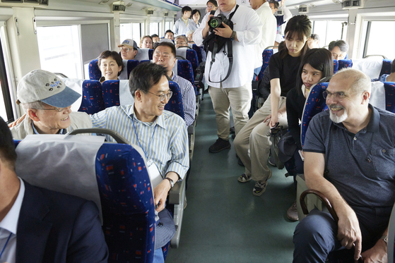 Gyeonggi Gov. Kim Dong-yeon, second from left, talks with French Ambassador to Korea Philippe Lefort on a train to Dorasan Station in Paju, Gyeonggi, Saturday, to participate in the so-called DMZ Peace Walk event. [GYEONGGI PROVINCIAL GOVERNMENT OFFICE]