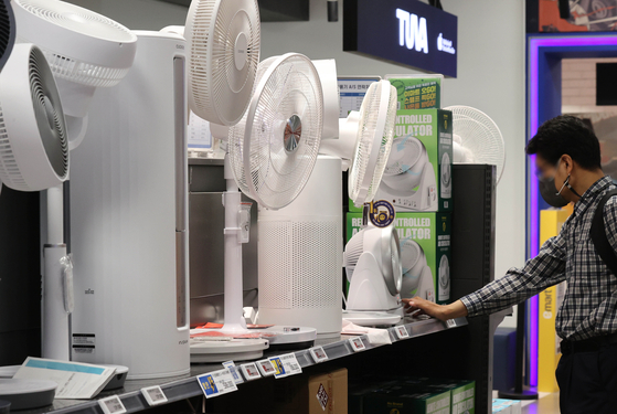 A customer looks at a fan at a discount mart in Seoul, Sunday. Fans have been gaining popularity since last year, driven by high commodity prices and rising fuel costs. Fan sales, which shrank in 2020 and 2021, rose 34.3 percent from April 1 to May 17 compared to the same period last year, following the previous year's 51.7-percent sales increase, according to Emart. [YONHAP]