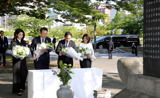 Korean President Yoon Suk Yeol, center left, and Japanese Prime Minister Fumio Kishida, center right, accompanied by first ladies Kim Keon-hee and Yuko Kishida, pay respects in front of a cenotaph for Korean victims of the 1945 Hiroshima atomic bombing at the Hiroshima Peace Memorial Park in Japan on Sunday. [JOINT PRESS CORPS]