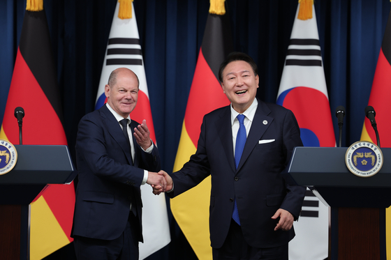 Korean President Yoon Suk Yeol, right, and German Chancellor Olaf Scholz shake hands during their bilateral summit at the Yongsan presidential office in central Seoul on Sunday evening. Both leaders attended the G7 Summit in Hiroshima that weekend. [PRESIDENTIAL OFFICE]