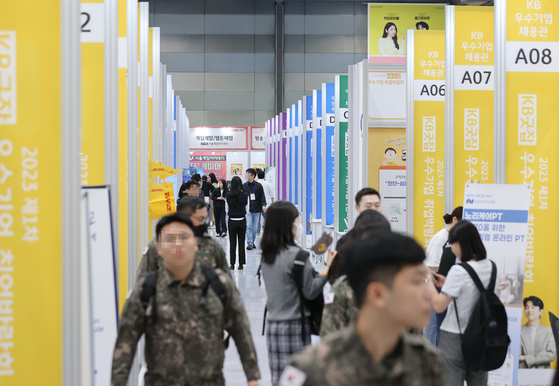Visitors look around booths at the 2023 1st KB Goodjob Job Fair hosted by KB GoodJob, a recruitment portal, at COEX, southern Seoul, Monday. The two-day job fair event first began in 2011. [YONHAP]