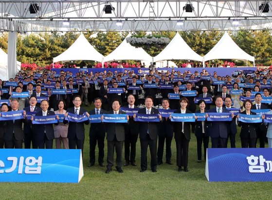 President Yoon Suk Yeol, center, poses for a picture with government officials and local business leaders at the 34th conference of small and medium-sized enterprises held on the front lawn of the presidential office in Yongsan, central Seoul, on Tuesday. From left on front row, Hyundai Motor Group Executive Chair Euisun Chung; Finance Minister Choo Kyung-ho; Samsung Electronics Executive Chairman Lee Jae-yong; Korea Federation of SMEs Chairman Kim Ki-moon; President Yoon Suk Yeol; SK Group Chairman Chey Tae-won, second from right; and Minister of SMEs and Startups Lee Young, far right. [JOINT PRESS CORPS]