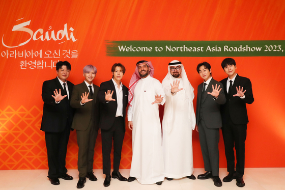 Members of boy band Super Junior pose for photos with officials from the Saudi Arabia Tourism Authority on Monday. [SM ENTERTAINMENT]