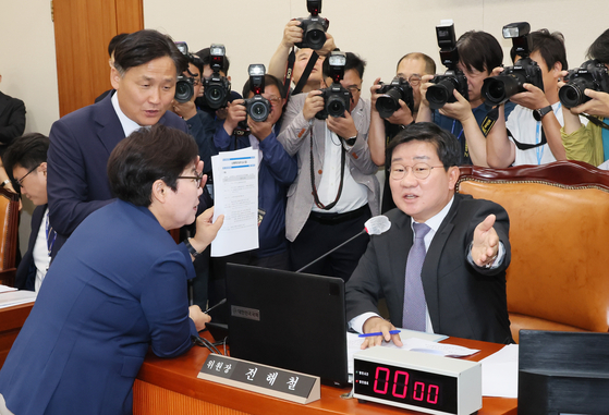 Rep. Lim Lee-ja of the People Power Party, left, protests the referral of a contentious pro-labor bill against Democratic Party Rep. Jeon Hae-cheol, head of the parliamentary Environment and Labor Committee, on Wednesday at the National Assembly in western Seoul. [YONHAP]