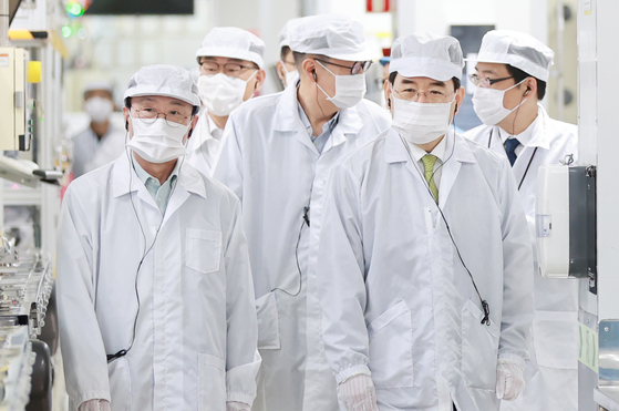 Industry Minister Lee Chang-yang, right, looks around LG Energy Solution's EV battery plant in Ochang, North Chungcheong, on Thursday. [NEWS1]