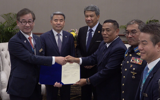 Korea Aerospace Industries CEO Kang Goo-young, left, shakes hand with Malaysian Defense Ministry Secretary General Dato’ Sri Muez bin Abd Aziz with the contract on delivering 18 FA-50M light combat aircraft at the Langkawi International Maritime and Aerospace Exhibition (LIMA) in Malaysia. Korean Defense Minister Lee Jong-sup, second from left, and Malaysian Defense Minister Dato' Seri Utama Haji Mohamad bin Haji Hasan, third from left, also attended the signing ceremony. [KOREA AEROSPACE INDUSTRIES]